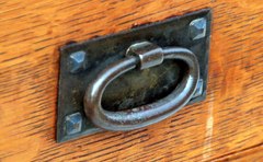 Detail Gustav Stickley early hand hammered oval iron pull with pyramidal screws circa 1904 to 1906.